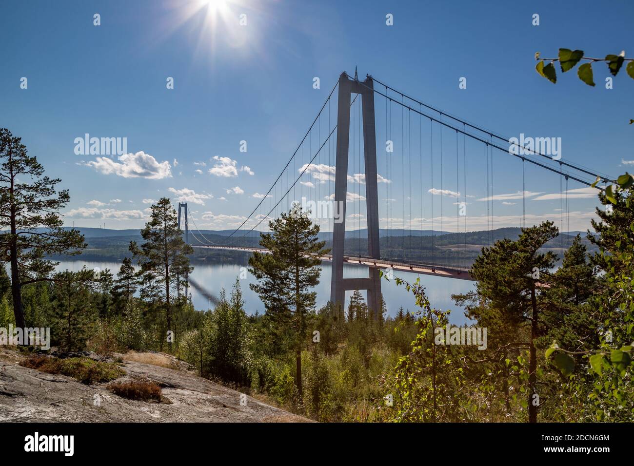 Höga Kustenbron, eine Hängebrücke über den Fluss Ångermanälven unter blauem, sonnigem Himmel bei Veda, Schweden. Stockfoto