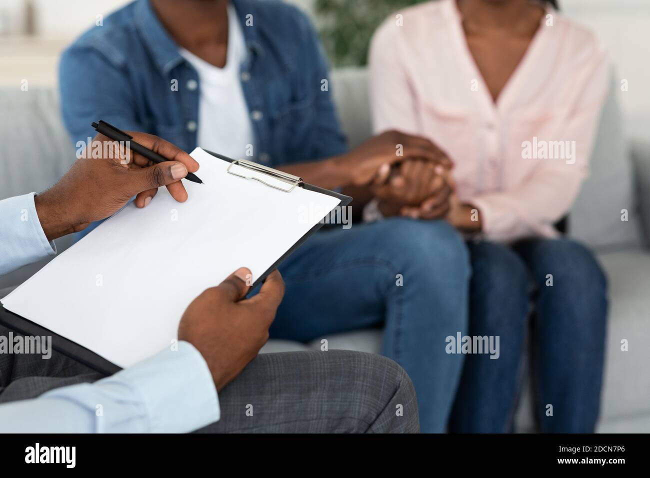 Ehelfer Nimmt Notizen Bei Der Therapie-Sitzung Mit Afroamerikaner Ehepartner Stockfoto