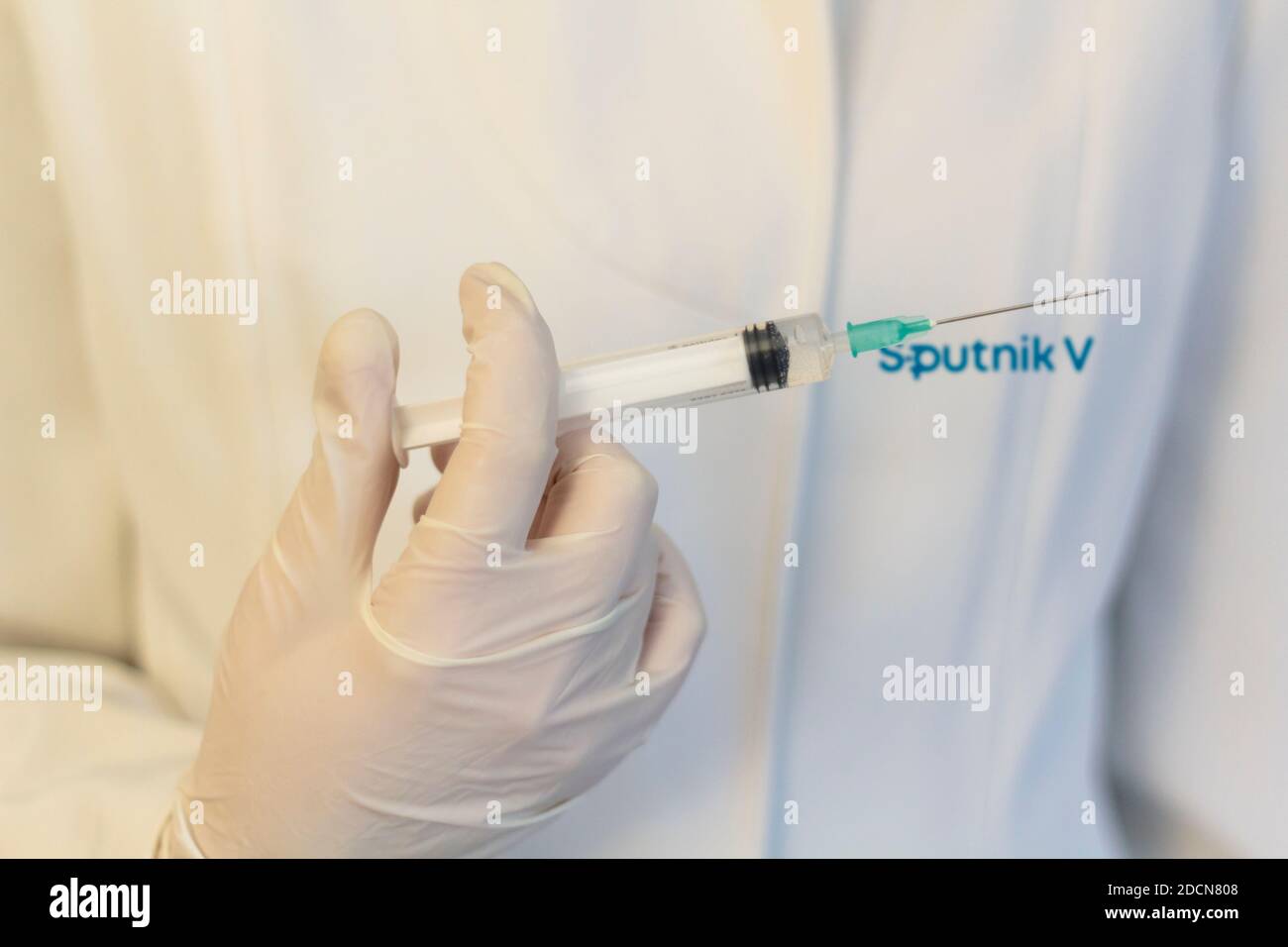 Lissabon, Portugal - 22. November 2020: Medic ,Wissenschaftler, Apotheker mit Spritze mit Sputnik V Logo auf Labormantel. Coronavirus, Covid-19 Vakzine Konz Stockfoto
