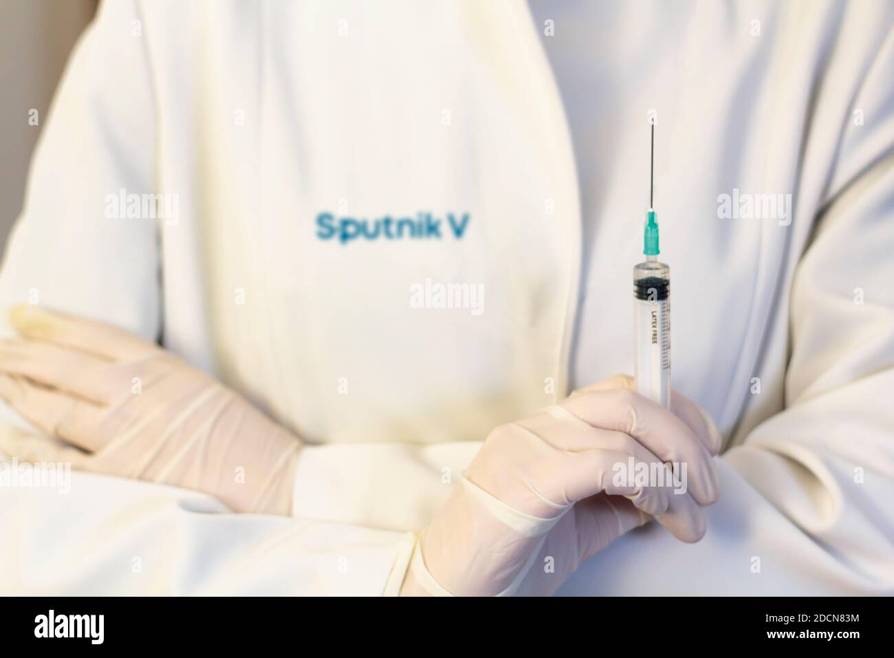 Lissabon, Portugal - 22. November 2020: Medic ,Wissenschaftler, Apotheker mit Spritze mit Sputnik V Logo auf Labormantel. Coronavirus, Covid-19 Vakzine Konz Stockfoto