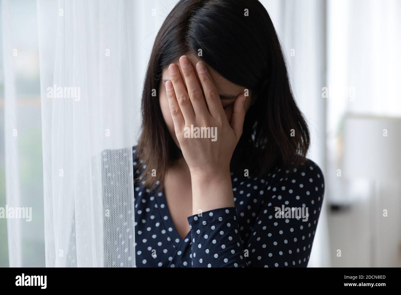 Nahaufnahme frustriert asiatische Frau Gesicht bedeckt, denken über Probleme Stockfoto