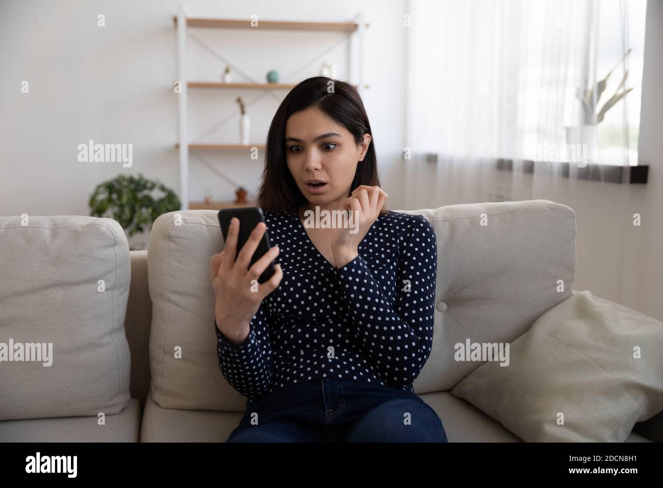 Schockiert unglücklich asiatische junge Frau Blick auf Telefonbildschirm Stockfoto