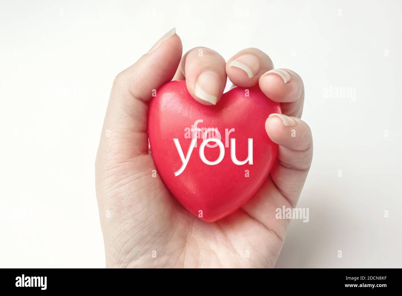 Hand hält rotes Herz mit Text FÜR SIE, Gesundheit, spenden und Familienversicherung Konzept. Welt Herz Gesundheit Tag Idee. Komposition für Valentinstag, Stockfoto