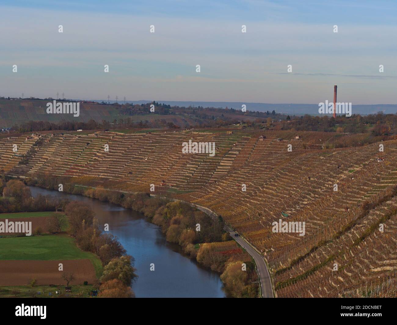 Schöner Blick auf den friedlich fließenden Neckar in einem Tal mit terrassenförmig angelegten Weinbergen am Hang und bunten Bäumen am Flussufer in der Herbstsaison. Stockfoto