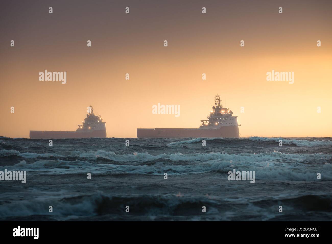 Schiffe, die während der goldenen Stunde auf den Eingang zum Hafen von aberdeen warten Stockfoto