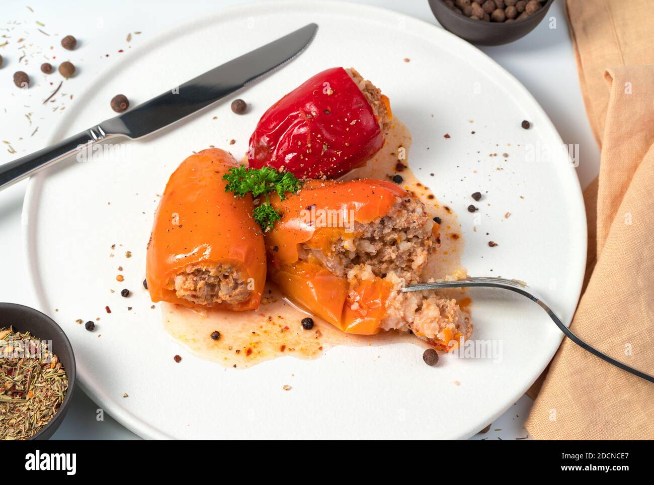 Leicht abgebrochen mit einer Gabel gefüllten Pfeffer mit Kräutern und Gewürzen auf einer weißen Platte. Stockfoto