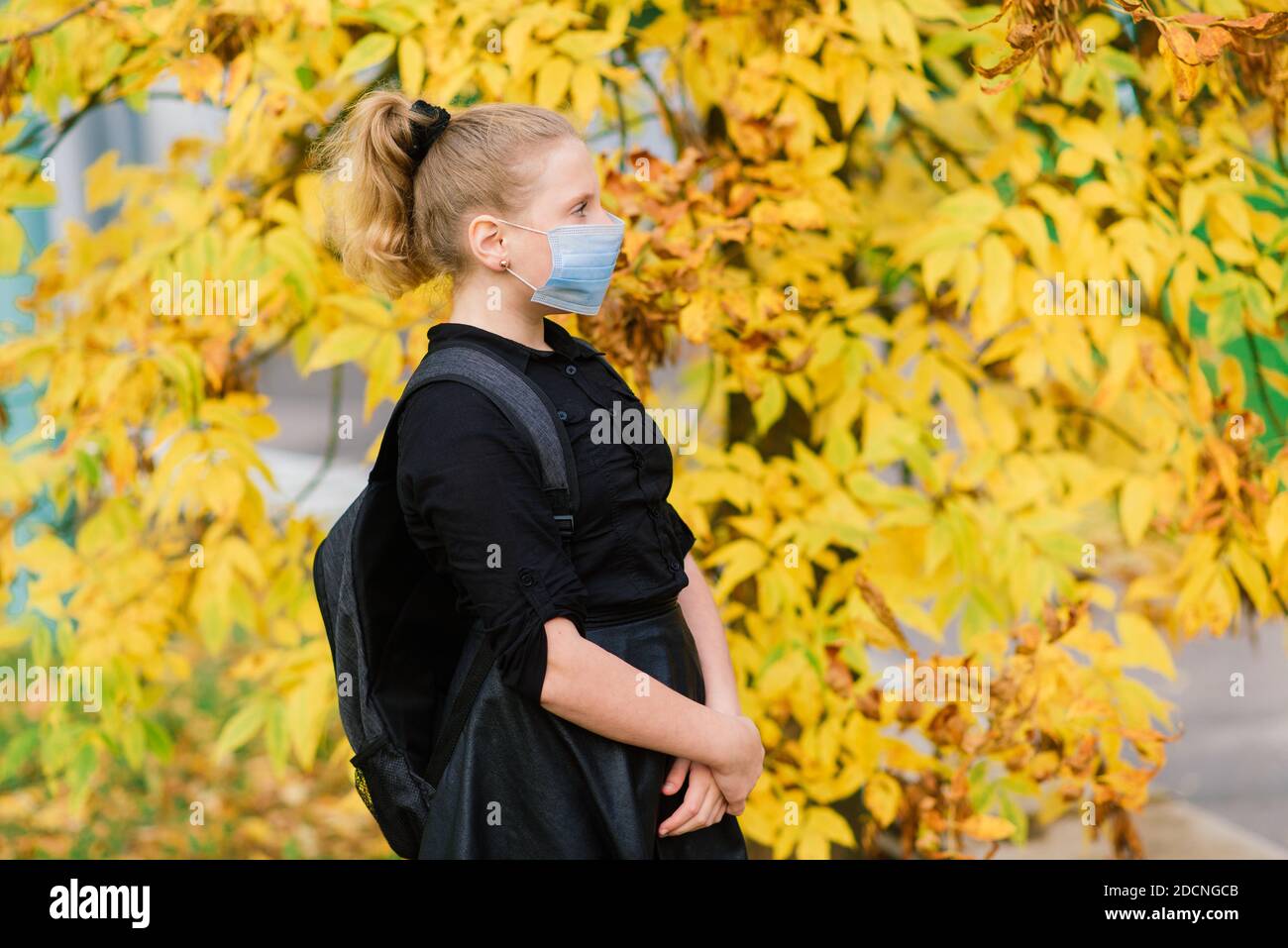 Aukasianische Schülerin Teenager in einer medizinischen Maske Schutz des Gesichts Auf dem Hintergrund einer herbstlichen Landschaft Stockfoto