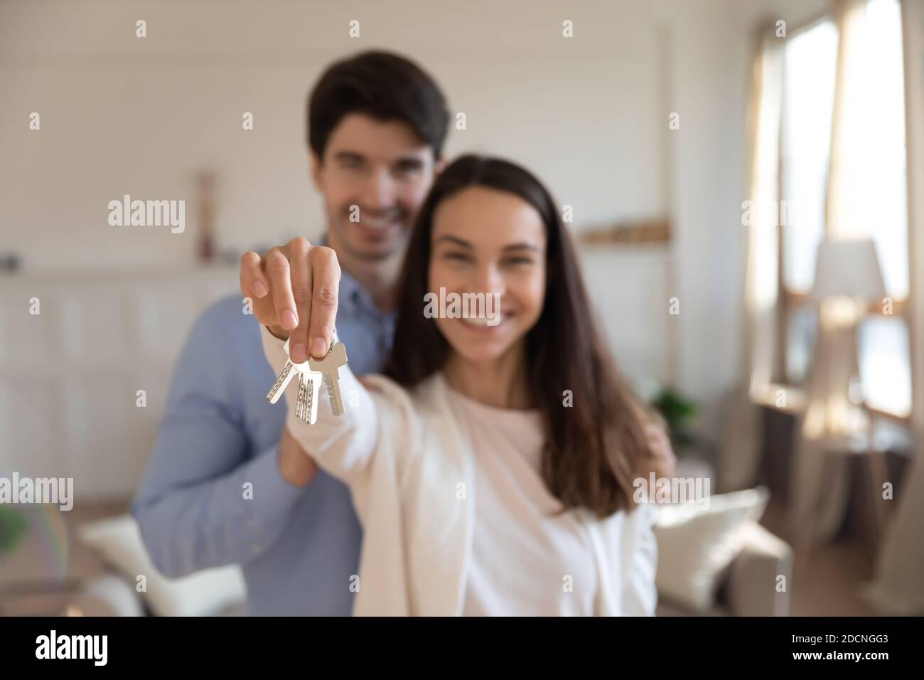 Glückliches Paar Käufer der Wohnung posiert mit Schlüsseln in den Händen Stockfoto