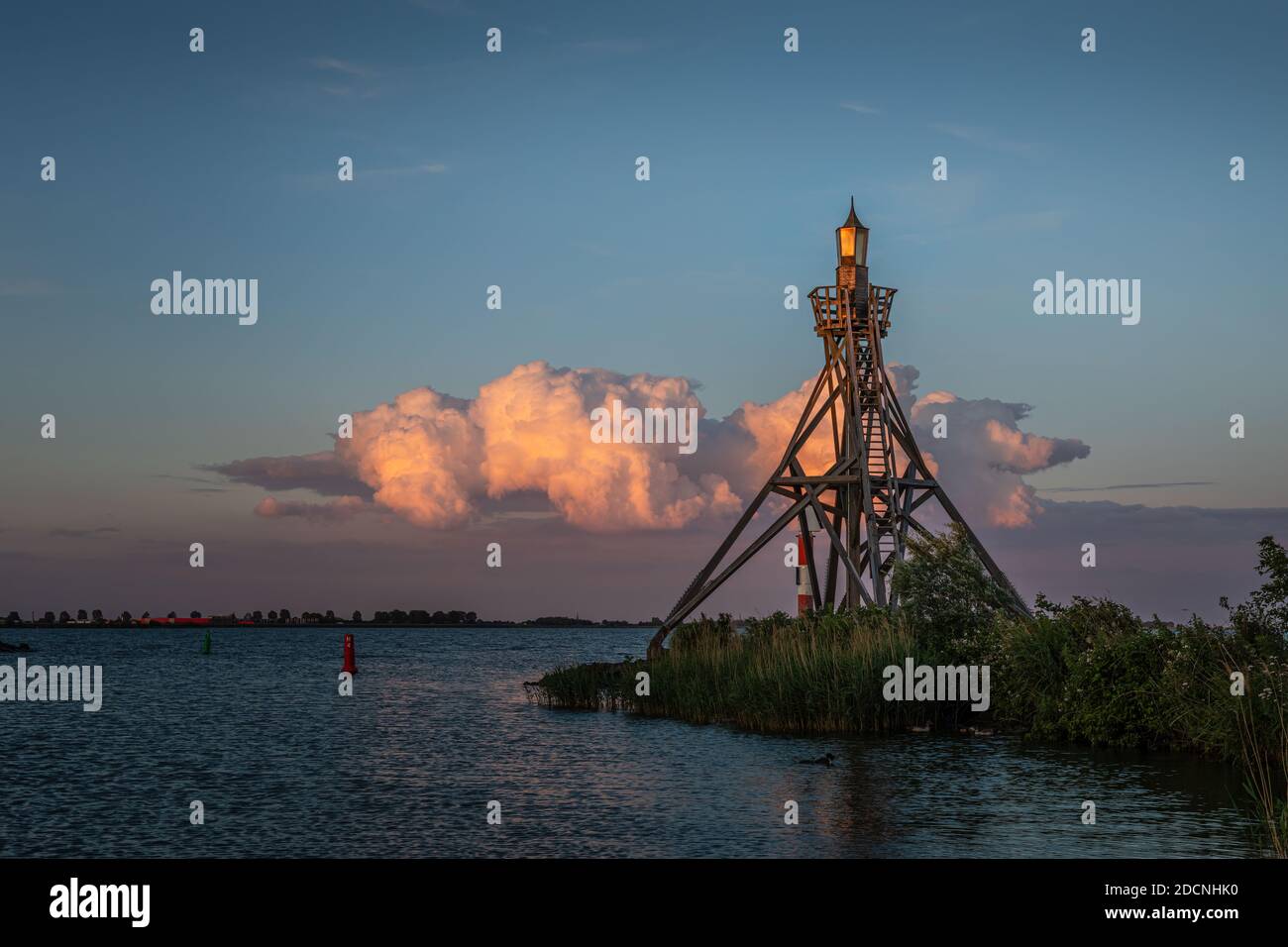 Old Hoorn Harbour Lighthouse kurz nach Sonnenuntergang mit einer beleuchteten Wolke im Hintergrund. Stockfoto