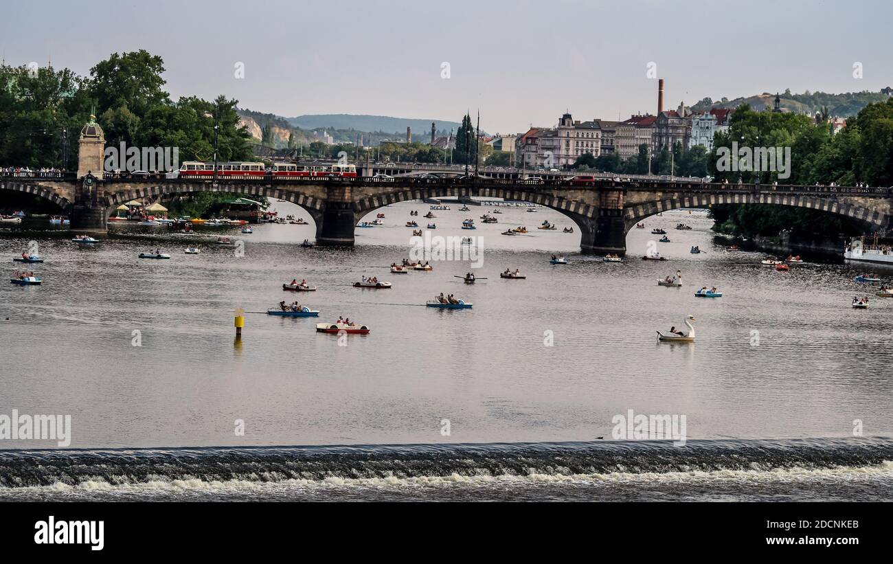 PRAG, TSCHECHISCHE REPUBLIK: Straßenbahnbrücke über die Moldau mit touristischen gemieteten Tretbooten Stockfoto