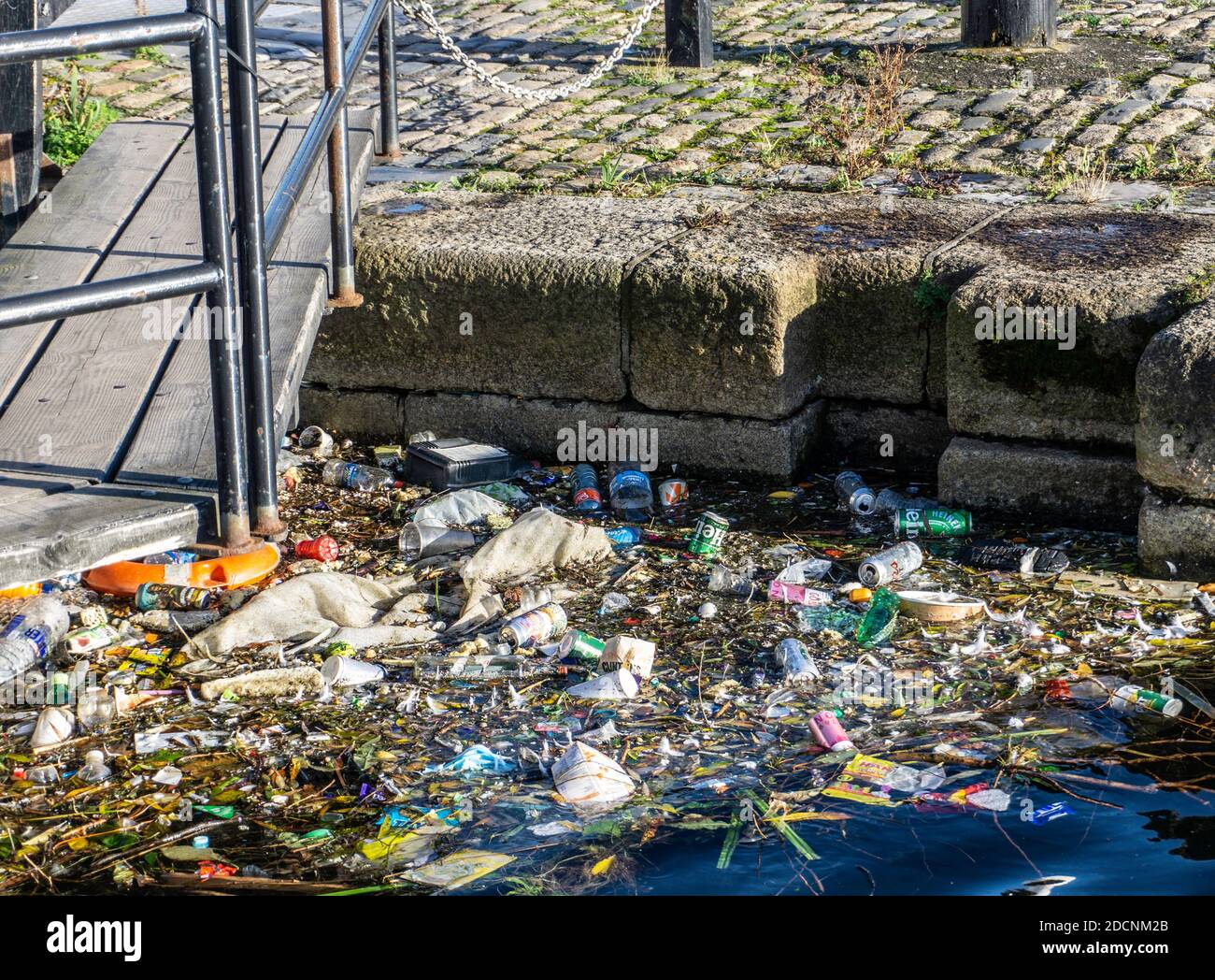 Müll wurde in einen Teil des Liffey in Dublin, Irland, gespült. Der Transport umfasst leere Bierdosen, Plastikflaschen, Lebensmittelbehälter usw. Stockfoto