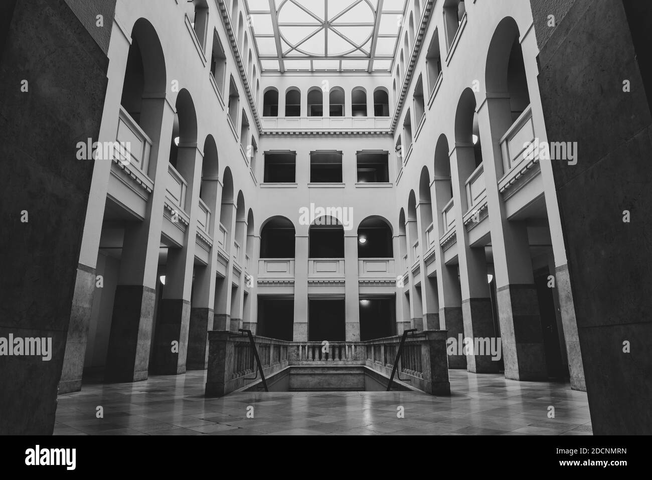 Historisches Atrium im Peter Behrens Gebäude Berlin, schönes helles Atrium, Atrium mit Bögen, öffentliches Gebäude, schwarz-weiß Foto Stockfoto
