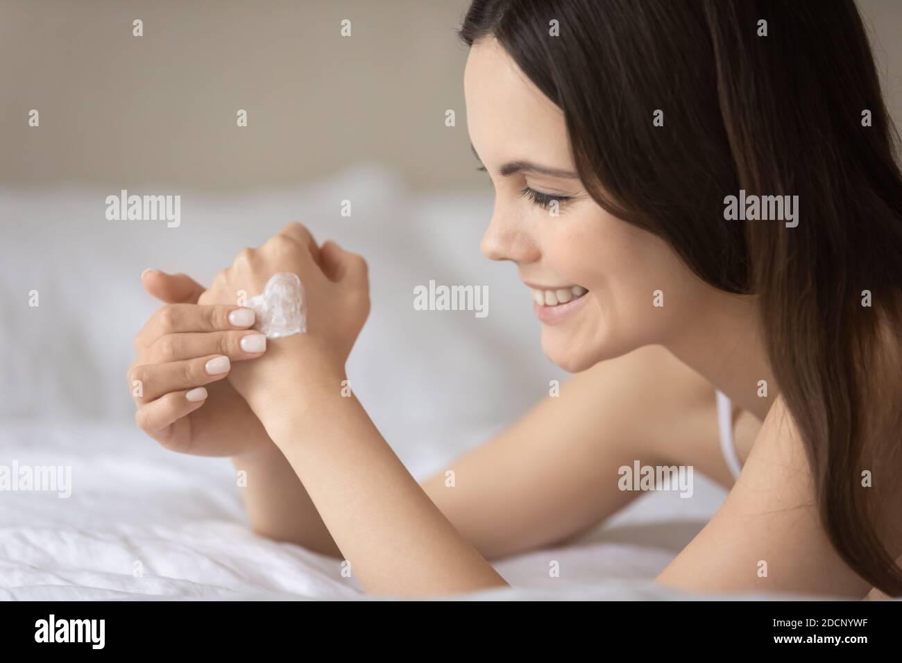 Inhalt junge Frau genießen Schönheitspflege Anwendung Lotion auf der Hand Stockfoto