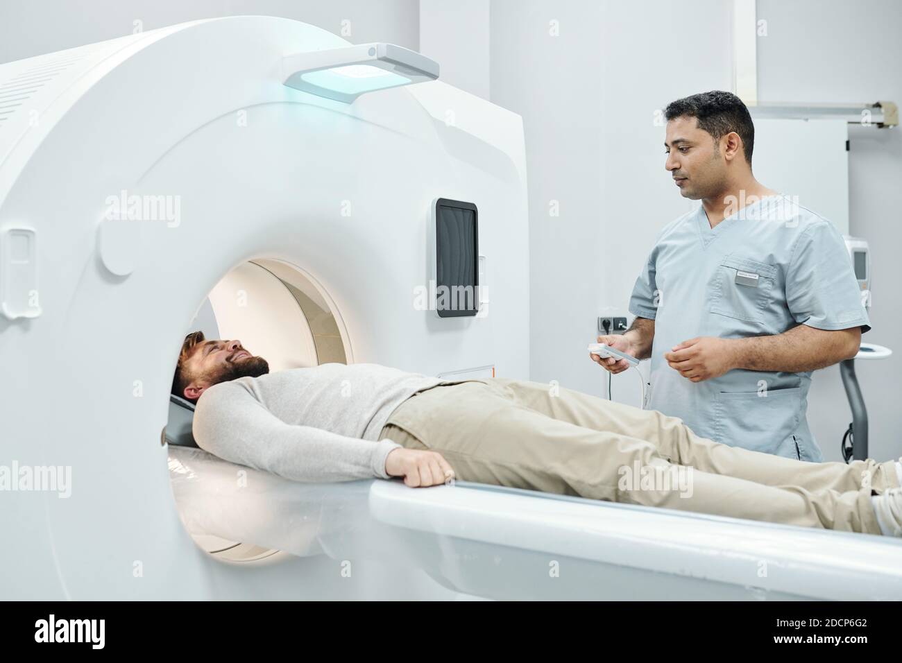 Junge Mischrasse männlichen Arzt in medizinischen Uniform berühren Taste auf Bedienfeld Stockfoto