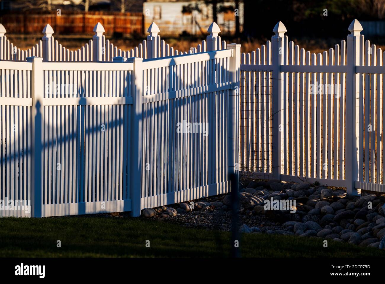 Weißer Vinyl-Pfostenstil Zaun und Schatten; Salida; Colorado; USA Stockfoto