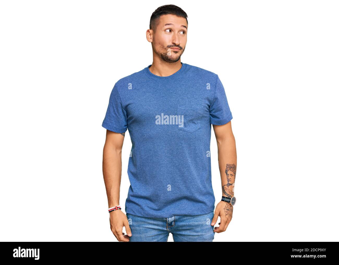 Schöner Mann mit Tattoos tragen lässige Kleidung lächelnd Blick auf die Seite und starrte weg denken. Stockfoto