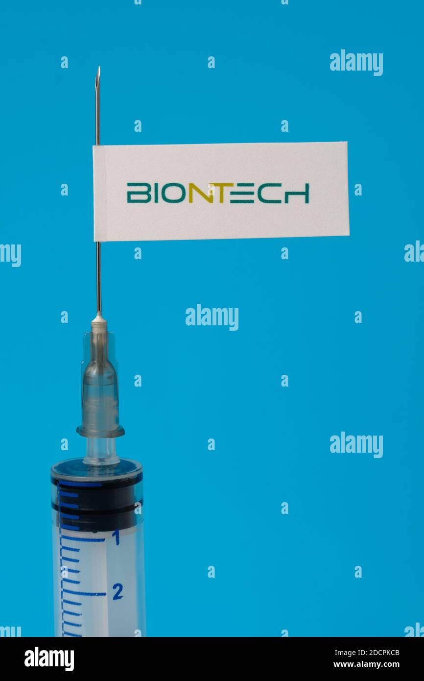 Stafford / Vereinigtes Königreich - November 22 2020: BioNTech-Impfstoff Covid-19 Konzept. Spritzennadel und Aufkleber darauf, verschwommener Hintergrund. Echtes Foto, nicht Stockfoto