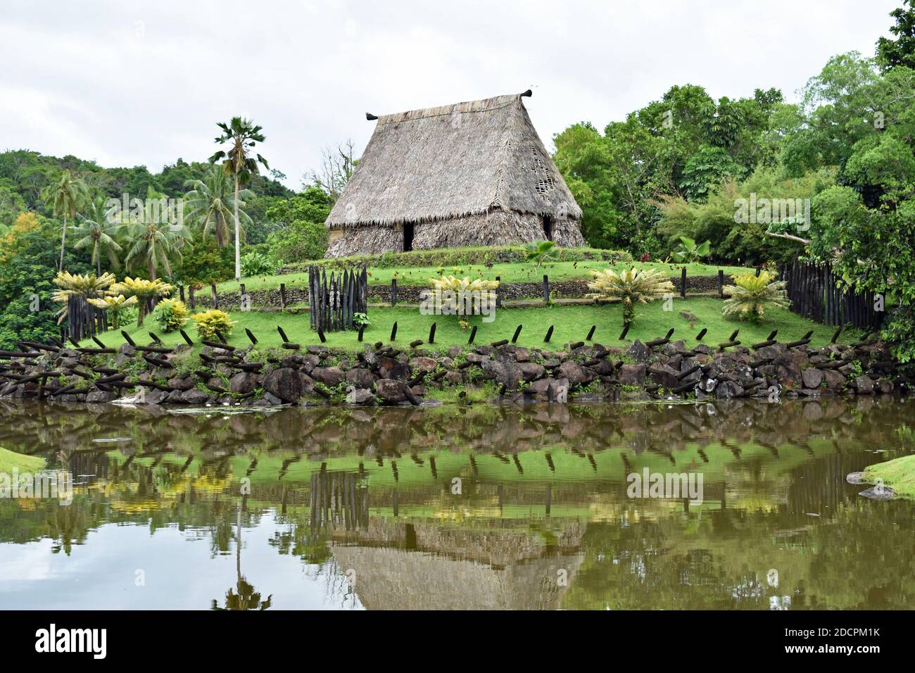 Das Bure Kalau (Geisterhaus) im Pacific Harbour Arts Village in der Nähe von Suva in Fidschi. Das Haus ist und Grün spiegelt sich in einem kleinen See. Stockfoto