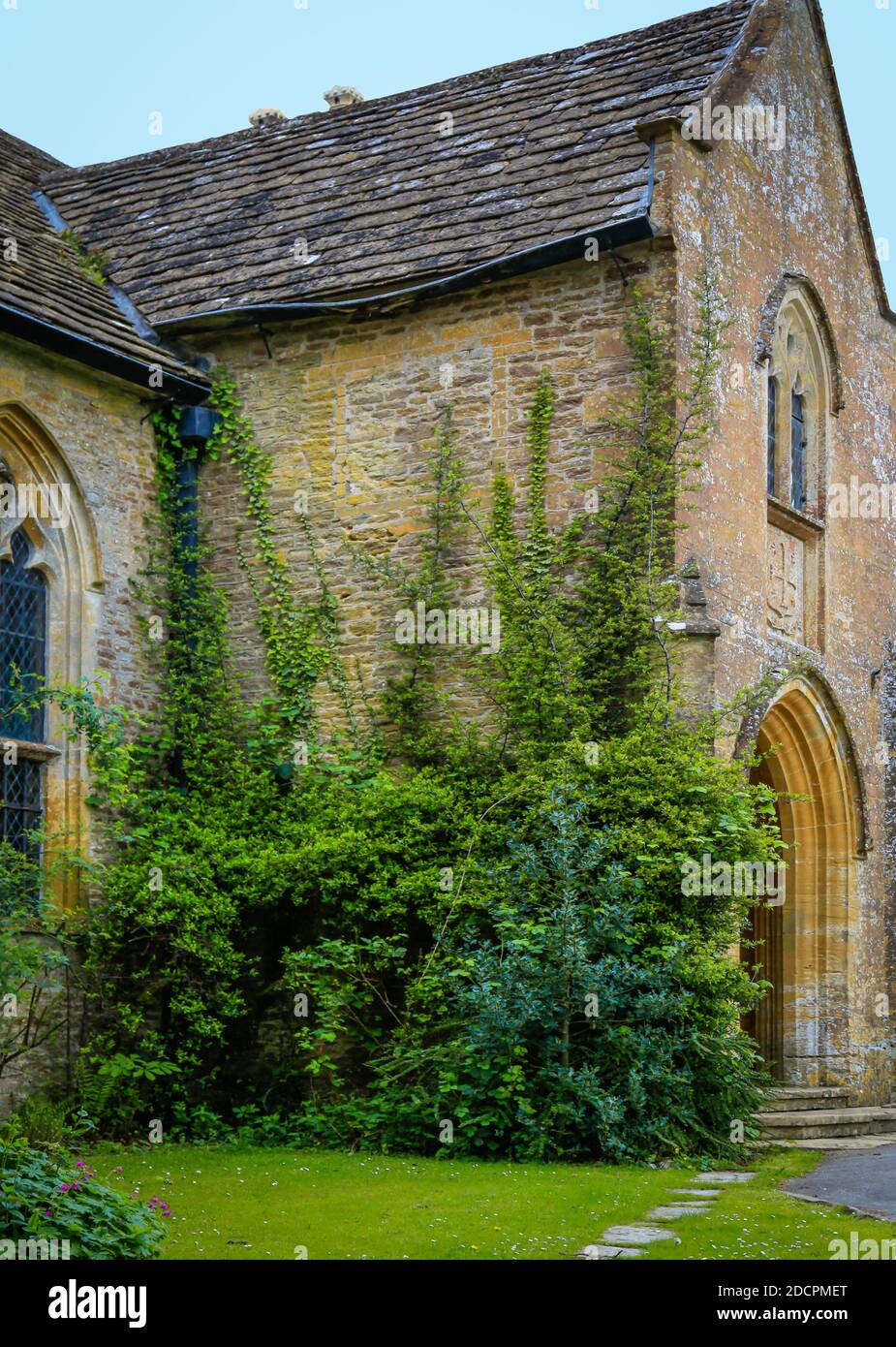 Klettern Reben auf einer alten Steinmauer der historischen St. Michael & All Angles Kirche in East Coker, County Somerset, England, Großbritannien Stockfoto