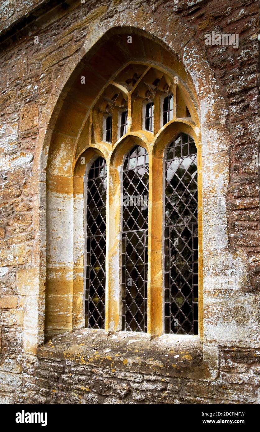 Nahaufnahme von Bleiglasfenstern in Bogenform in der St. Michael & All Angles Church der Klasse II* im Dorf East Coker, England, Großbritannien Stockfoto