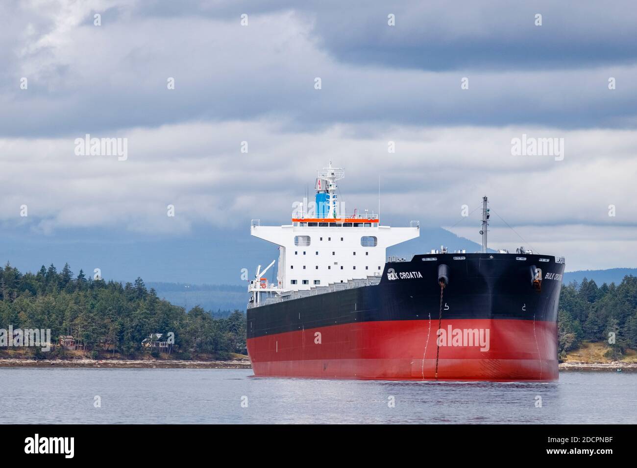 Vor Thetis Island, BC, vor Anker liegt der 228 Meter lange Frachter 'Bulk Croatia', der über der Küste thront und lokale Wut und Kontroversen auslöst. Stockfoto