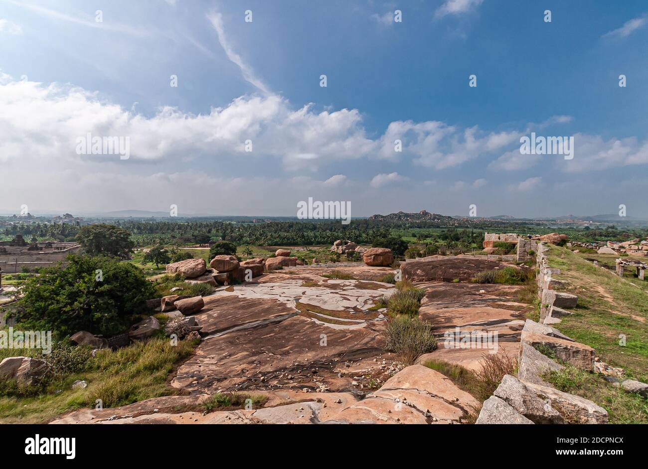 Hampi, Karnataka, Indien - 4. November 2013: Sunset Hill aka Hemakatu. Walls Ruinen und Felsbrocken unter blauer Wolkenlandschaft. Stockfoto