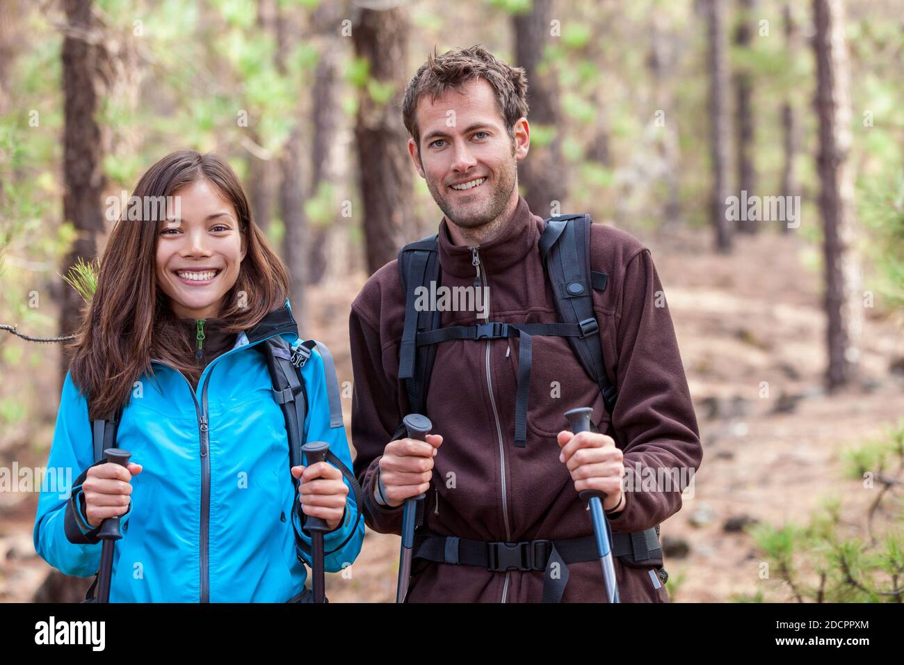Glückliche junge multirassische Menschen Wandern im Freien in Naturwald. Gesundes Paar multiethnische Gruppe. Lächelnde asiatische Frau und kaukasischen Mann im Herbst. Stockfoto