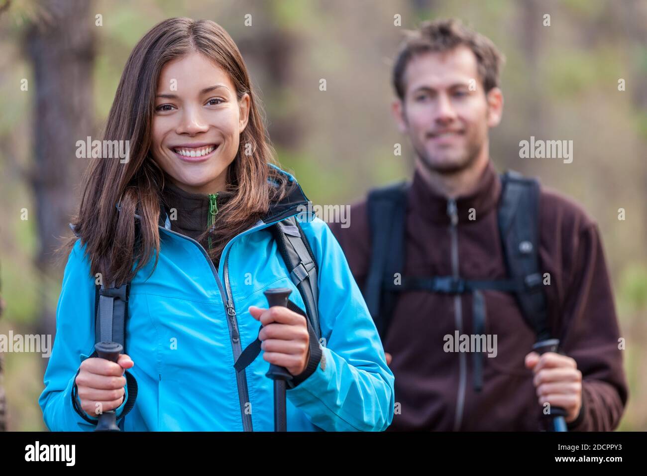 Glückliche junge multirassische Menschen Wandern im Freien in Naturwald. Lächelnde asiatische Frau und kaukasischen Mann im Herbst. Stockfoto