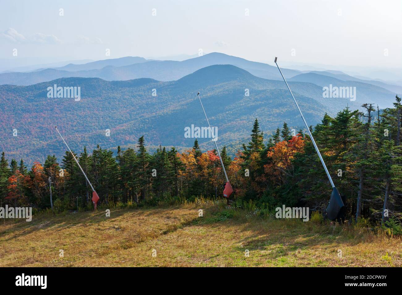 Ridgeview Skipiste in Stowe, VT, USA. Schnee Schnürsenkel säumen die Piste. Gemischter Wald mit Bäumen, die im Herbst ihre Farbe ändern. Dunstig über den Ausläufern Stockfoto
