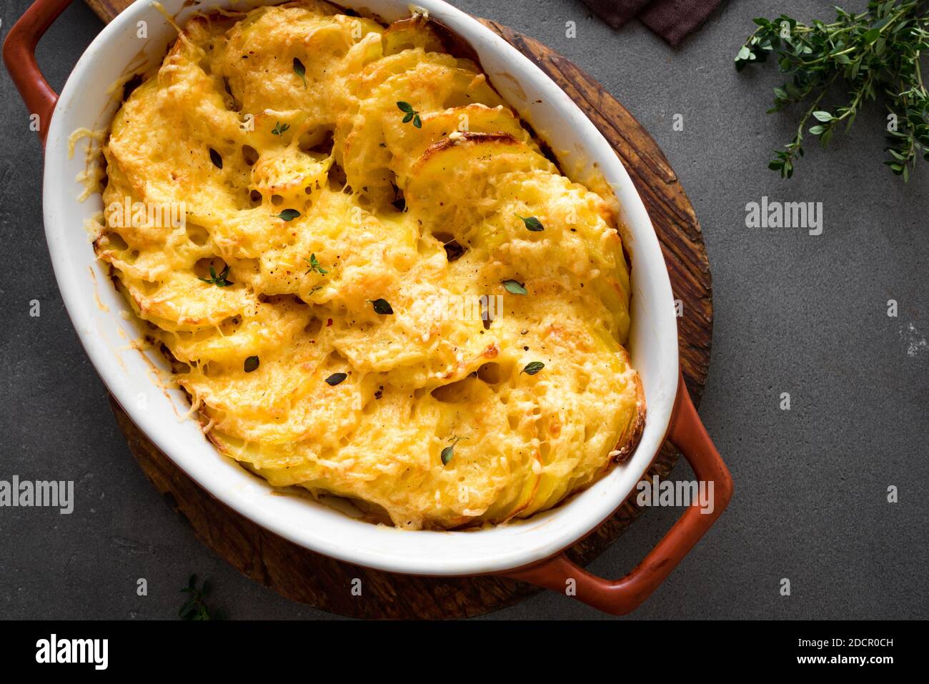 Kartoffelgratin. Frisch gebackene, kitschige Kartoffelauflauf auf dunklem Tisch, Draufsicht, Nahaufnahme. Stockfoto