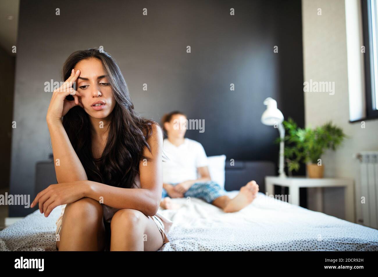 Junges Paar im Bett mit Problemen und Krise. Scheidung und Trennung Stockfoto