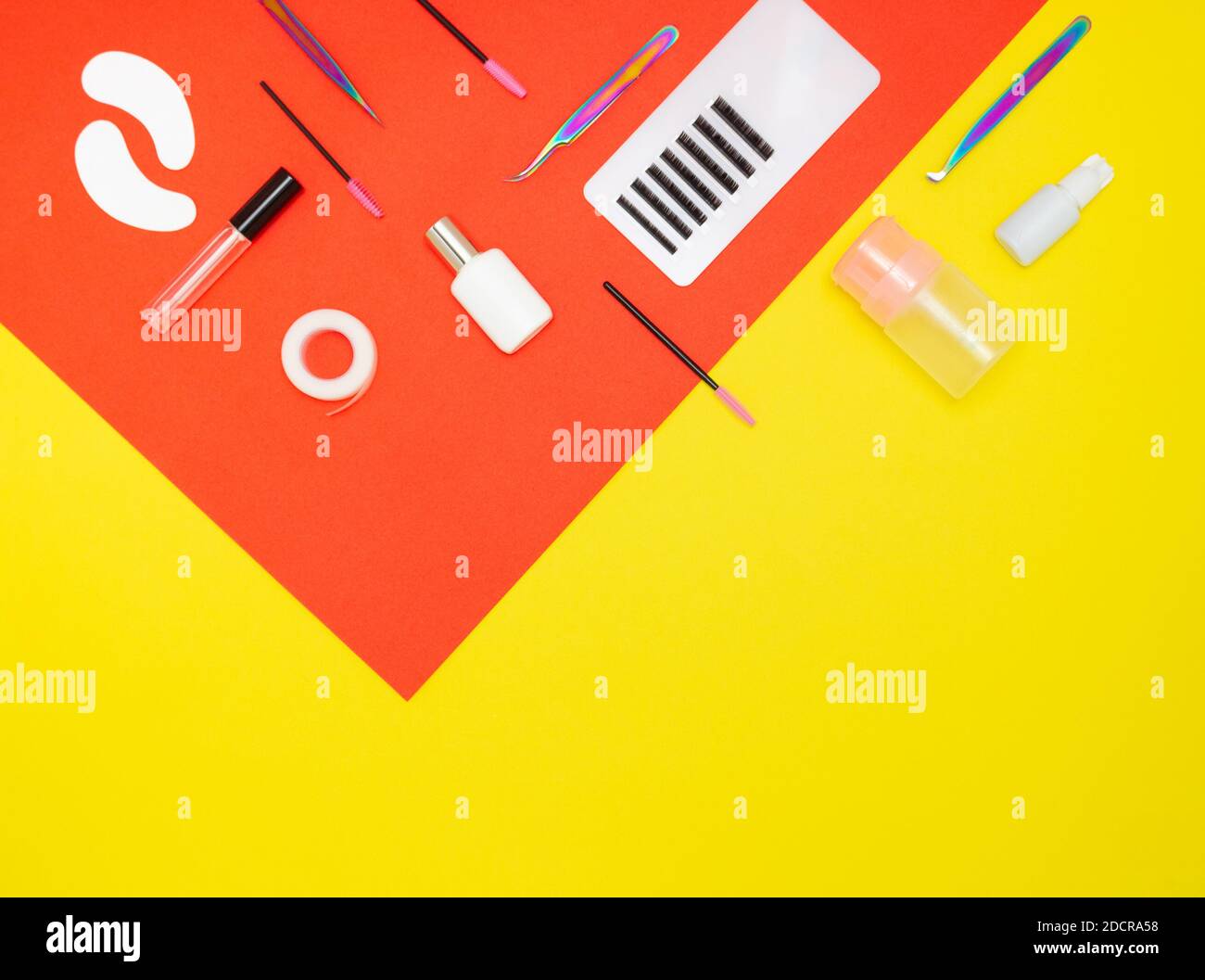 Werkzeuge für Wimpernverlängerung auf rotem und gelbem Hintergrund, Draufsicht. Wimpern, Flecken, Kleber, Kämme. Die Arbeit eines Lashmaker. Selbstversorgung, Schönheit salo Stockfoto