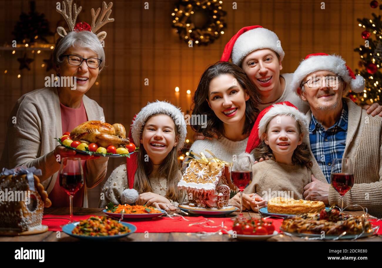 Frohe Weihnachten! Glückliche Familie essen zu Hause zu Abend. Feier Urlaub und Zweisamkeit in der Nähe von Baum. Stockfoto