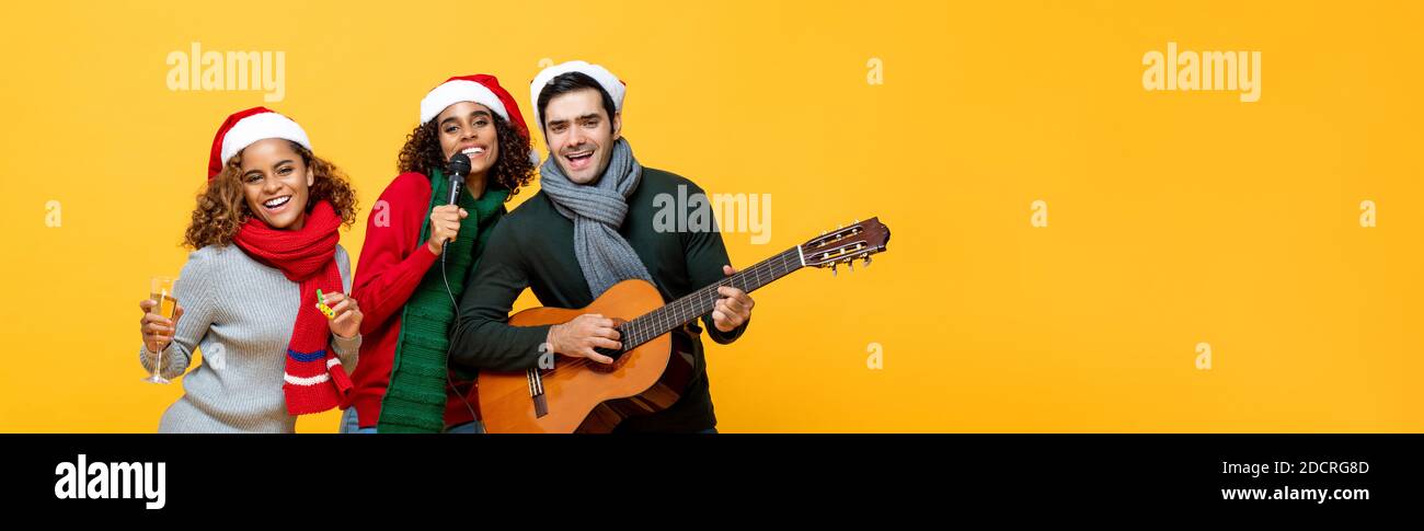 Portrait von verschiedenen Freunden, die Party singen trinken und feiern Weihnachten auf gelbem isoliertem Banner-Hintergrund mit Kopierraum Stockfoto