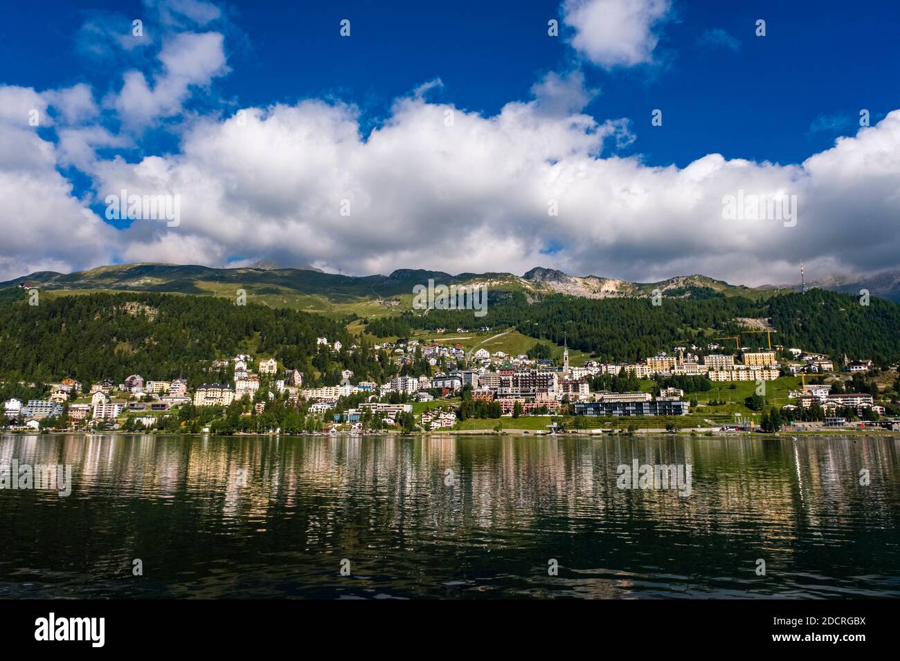 Die Stadt St. Moritz spiegelt sich im St. Moritzersee, den Südhängen der Albulalpen in der Ferne. Stockfoto
