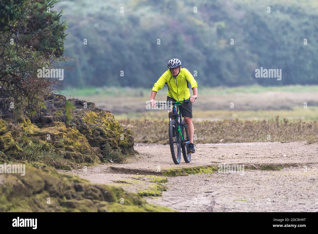 Ein reifer Radfahrer, der seine Galle entlang eines schlammigen Fußweges auf dem Gannel in Newquay in Cornwall reitet. Stockfoto