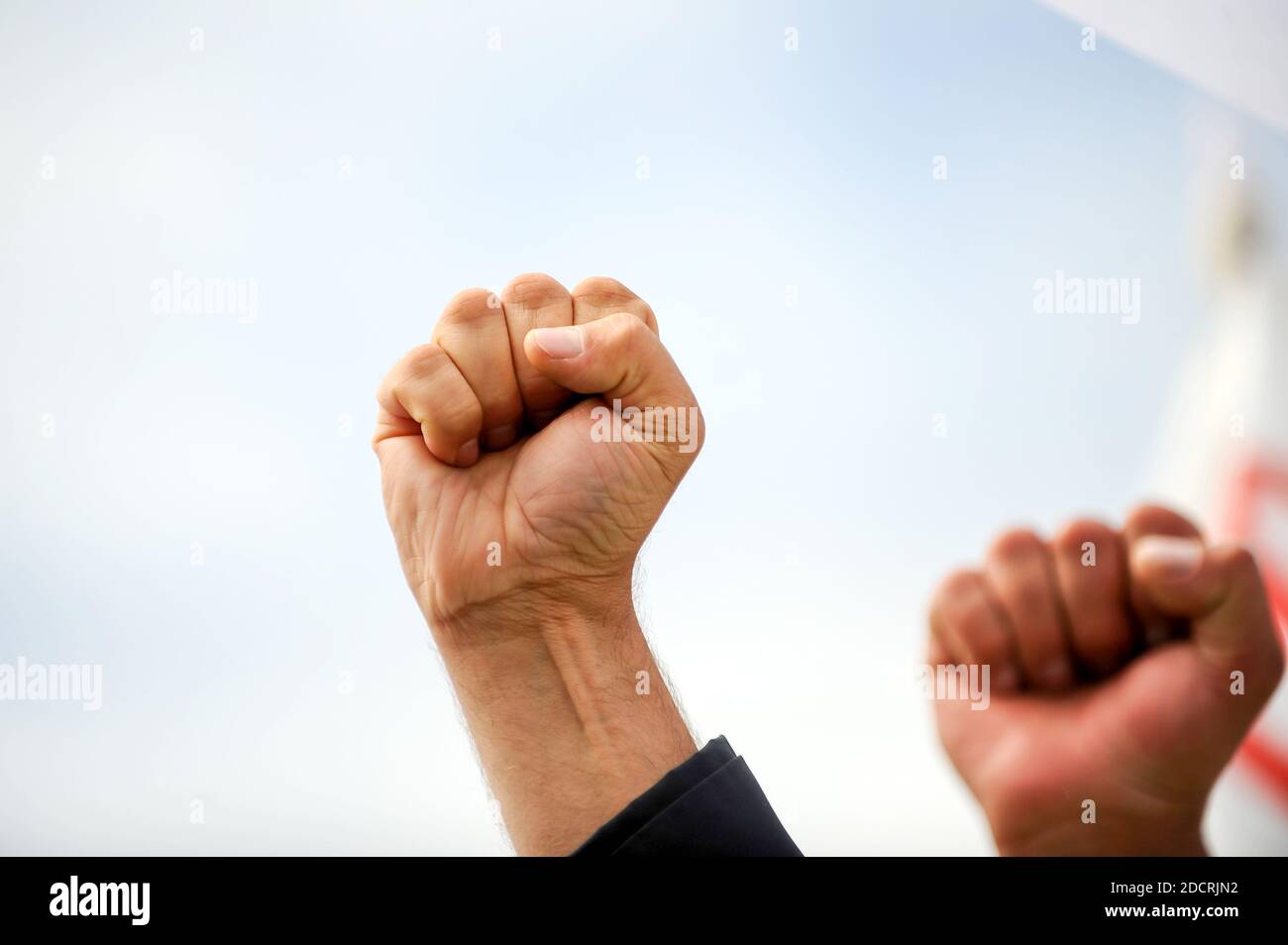 Details mit der geschlossenen Faust eines wütenden Protestierenden während einer politischen Kundgebung. Stockfoto