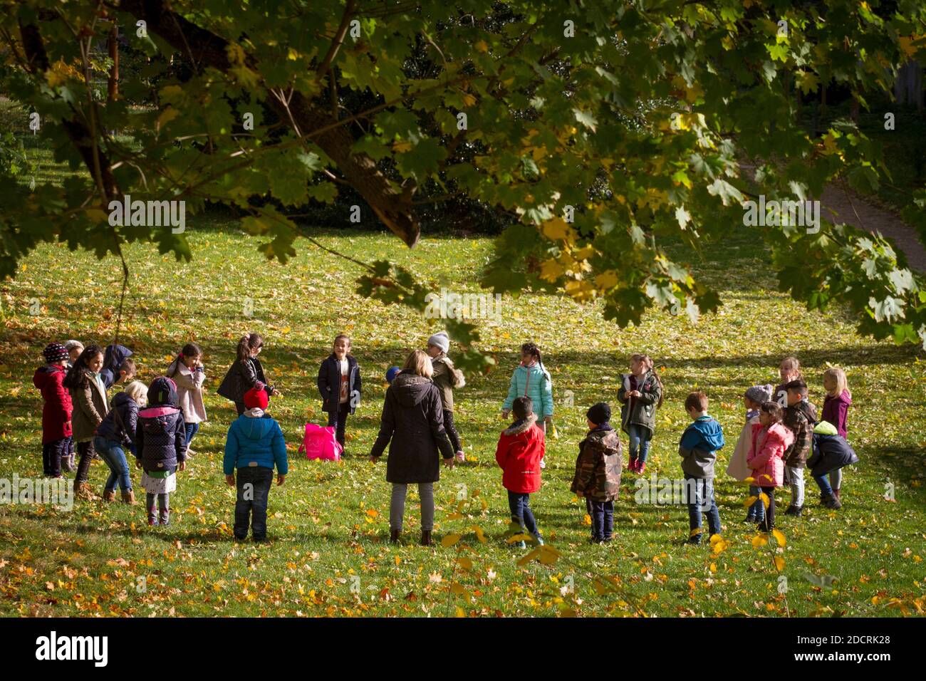 Schulkinder mit ihrem Lehrer in einem öffentlichen Park in Zeiten der Corona-Pandemie, Wetter Ruhr, Nordrhein-Westfalen, Deutschland. Schulkinder mit ei Stockfoto