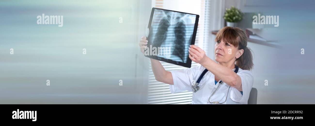 Ärztin untersucht Röntgenbericht im medizinischen Büro; Panorama-Banner Stockfoto