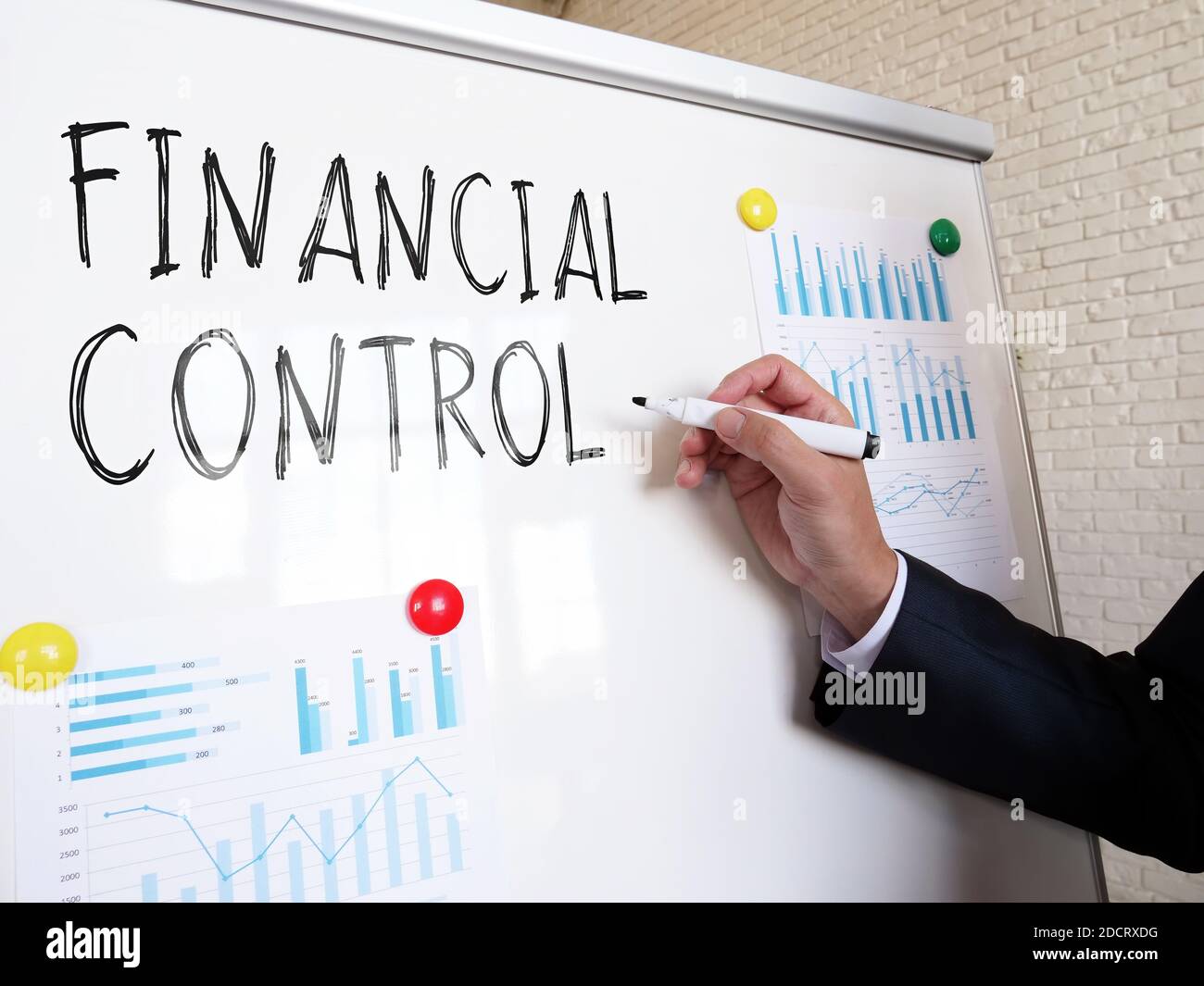 Der Wirtschaftsprüfer schreibt die Worte Finanzkontrolle auf das Whiteboard. Stockfoto