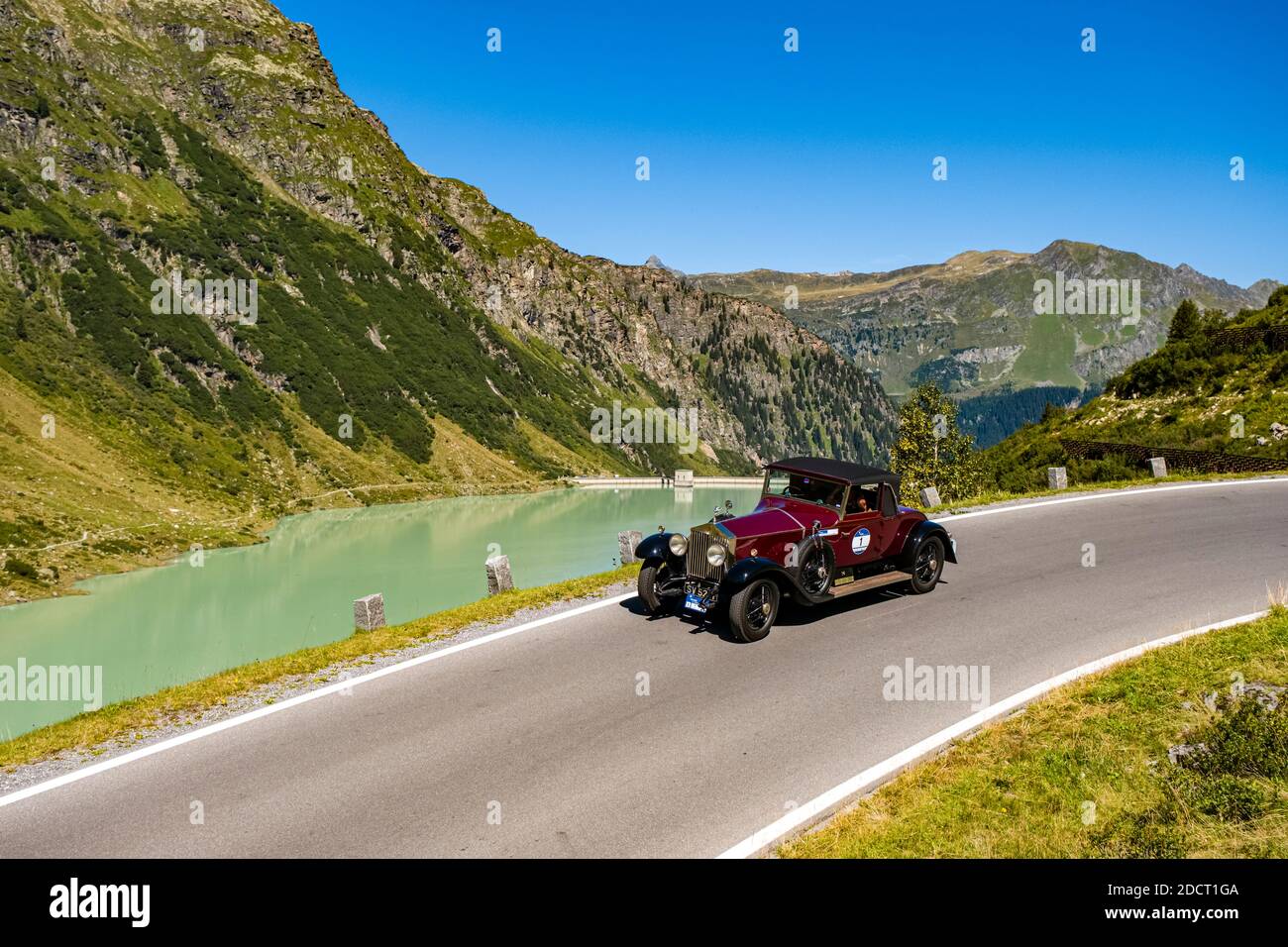 Ein Oldtimer Rolls Royce Phantom I Roadster, der während der Arlberg Classic Car Rally an einem See an der Silvretta Hochalpenstraße vorbeifährt. Stockfoto