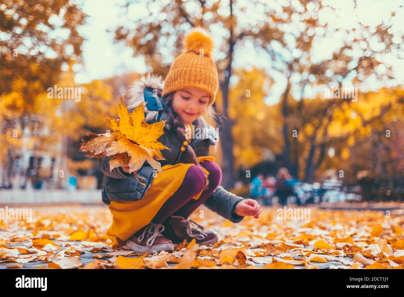 Kinder im Park mit Herbstblättern Stockfoto