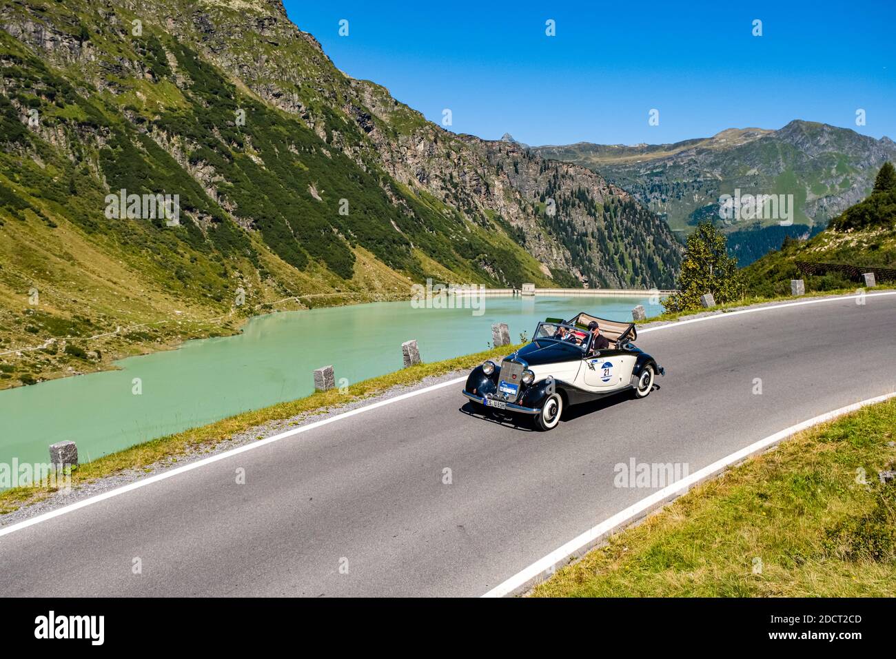 Ein Oldtimer Mercedes-Benz 170 V Cabrio fährt an einem See vorbei auf der Silvretta Hochalpenstraße während der Arlberg Classic Car Rally. Stockfoto