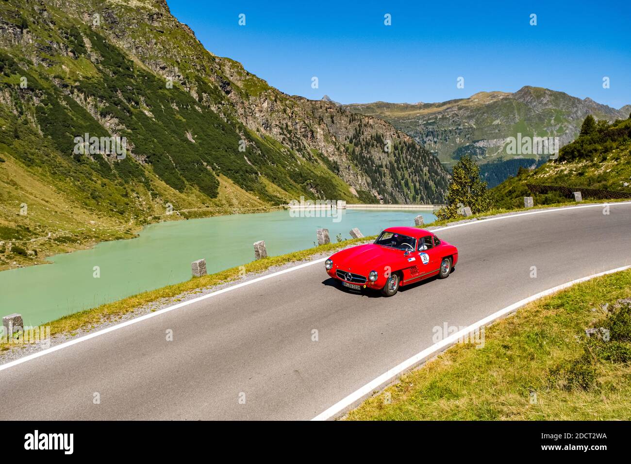 Ein Oldtimer Mercedes-Benz 300 SL fährt bei der Arlberg Classic Car Rally an einem See vorbei auf der Silvretta Hochalpenstraße. Stockfoto