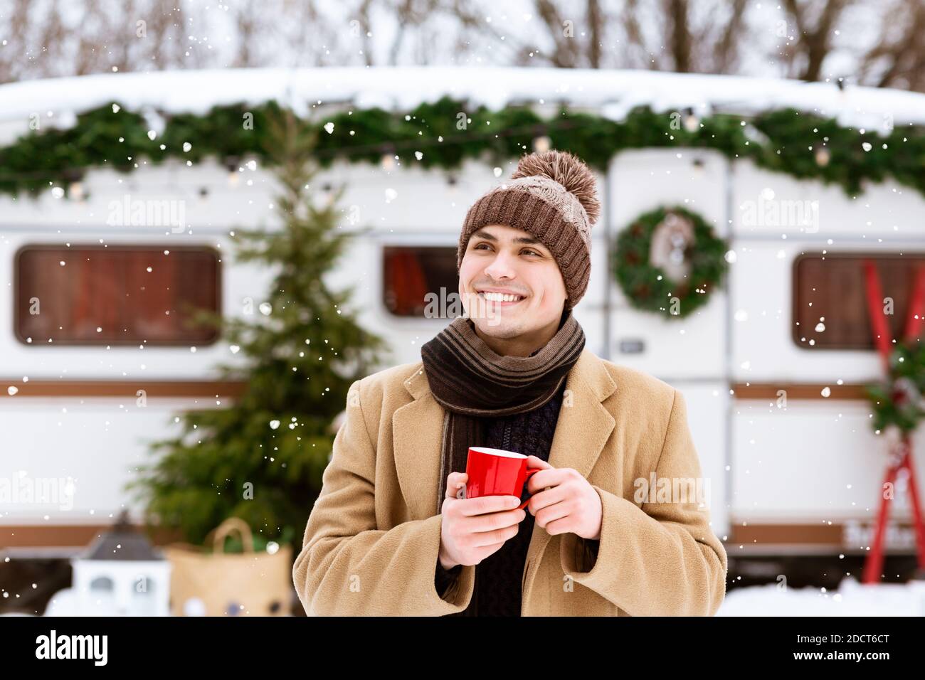 Hübscher Junger Mann Mit Roter Kaffeetasse, Der Im Freien Steht Wintercampingplatz Stockfoto