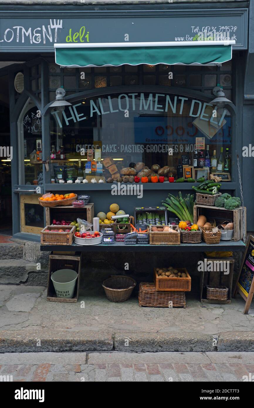 Die Fassade und die Vorderseite eines kleinen lokalen Ladens namens Allotment Deli in St. Ives, Cornwall, Großbritannien, der lokale Produkte wie Obst und Gemüse verkauft. Stockfoto