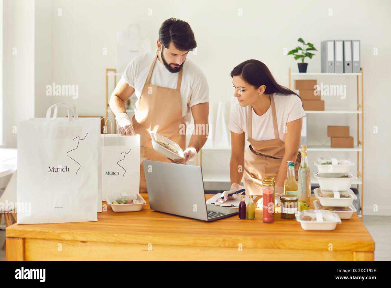 Mitarbeiter eines Restaurants bestellen einen Online-Lieferservice und verpacken ihn in Pakete. Stockfoto