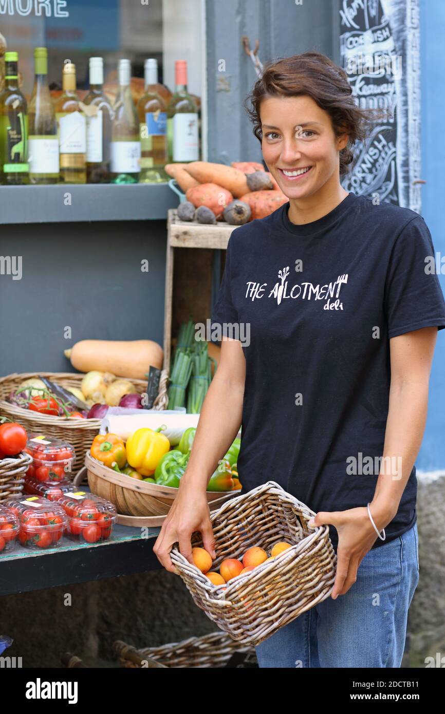 Porträt von weiblichen Verkäuferin mit Obst und Gemüse Kiste im Dorfladen Stockfoto