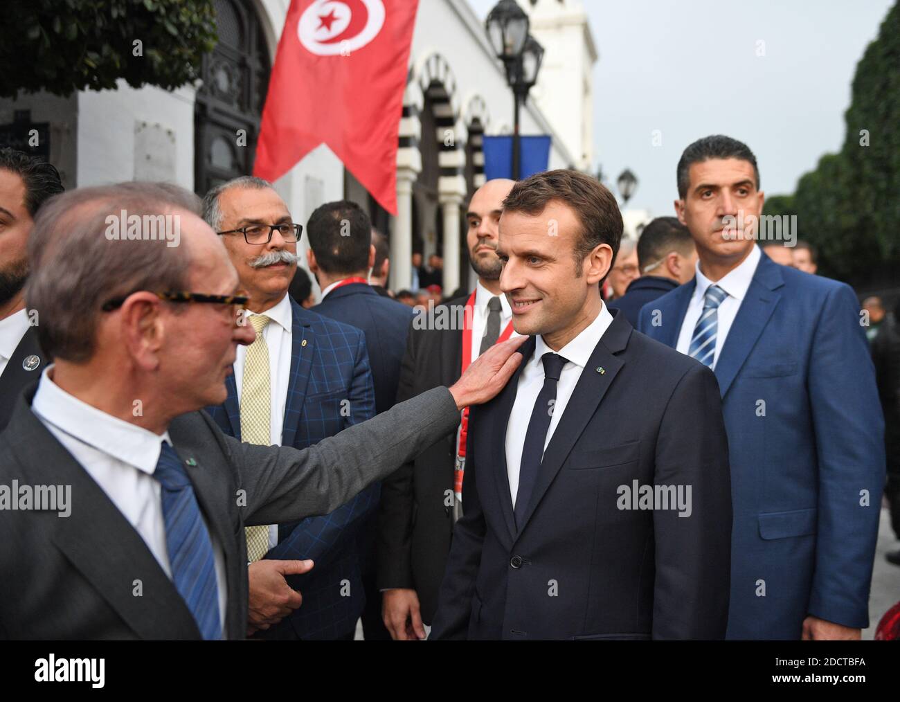 Der ehemalige Pariser Bürgermeister Bertrand Delanoe (L) klopfte dem französischen Präsidenten Emmanuel Macron (C-R) auf die Schulter, als sie am 1. Februar 2018 während Macrons erstem Besuch in dem nordafrikanischen Land vor dem Hauptquartier des Finanzministeriums in der tunesischen Hauptstadt Tunis stehen. Foto von Eric Feferberg/Pool/ABACAPRESS.COM Stockfoto