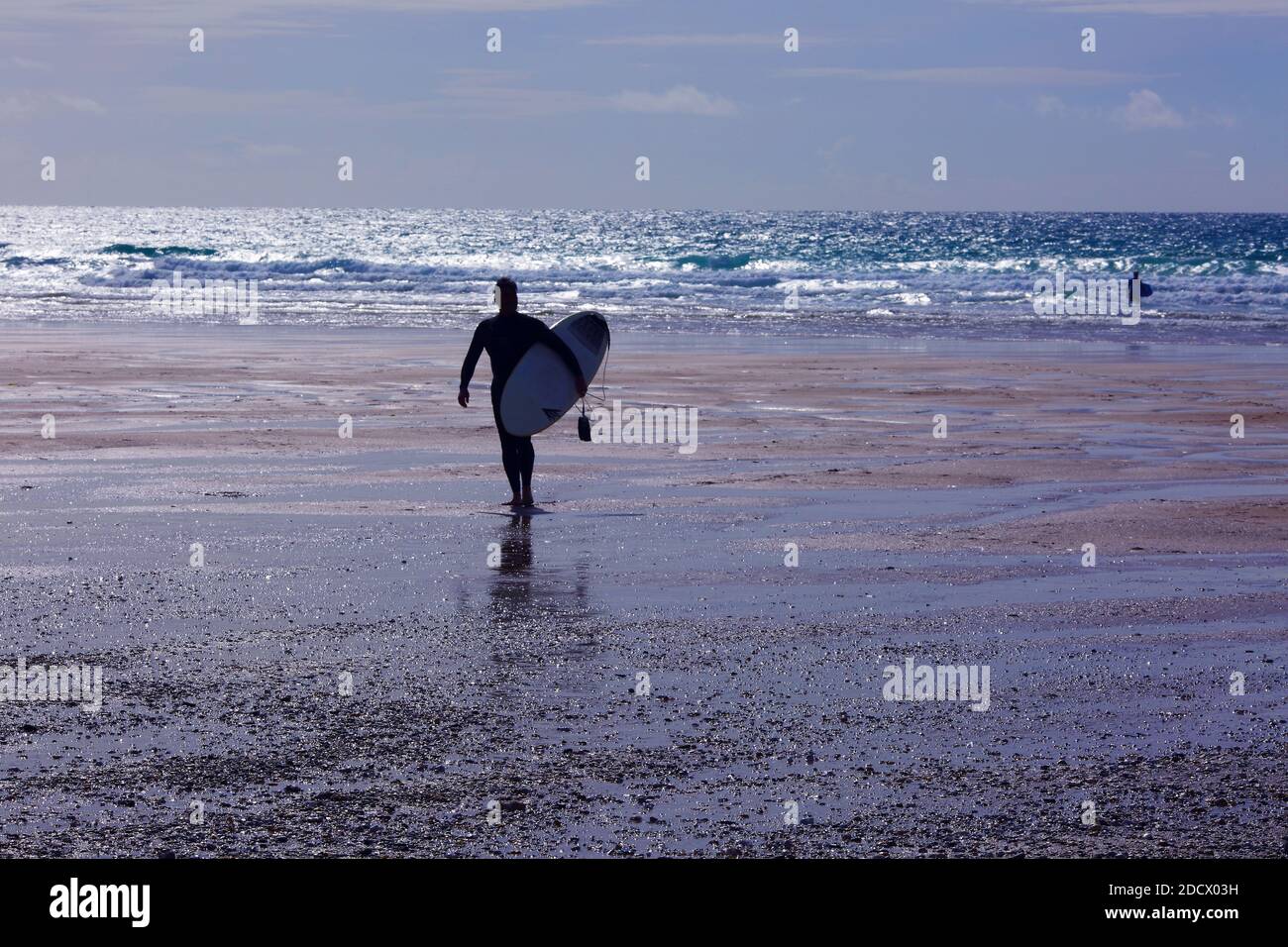 Surfer mit Surfbrett zu Fuß in Richtung Ozean am Fistral Beach Newquay, Cornwall, England Stockfoto
